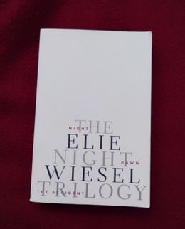 The Night Trilogy by Elie Wiesel, a white cover resting on deep red cloth.